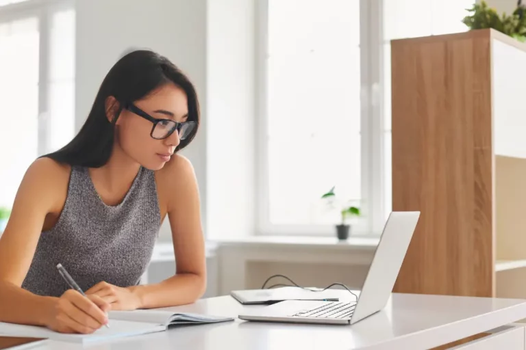 Student writing and looking at computer