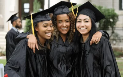 Three high school graduates smiling.