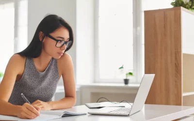 Student writing and looking at computer